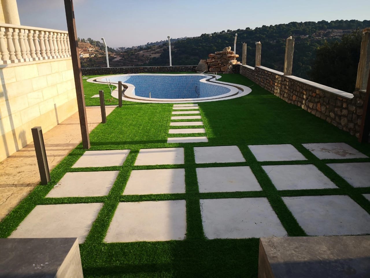 Artificial grass installation around a villa swimming pool near Sidon, Lebanon